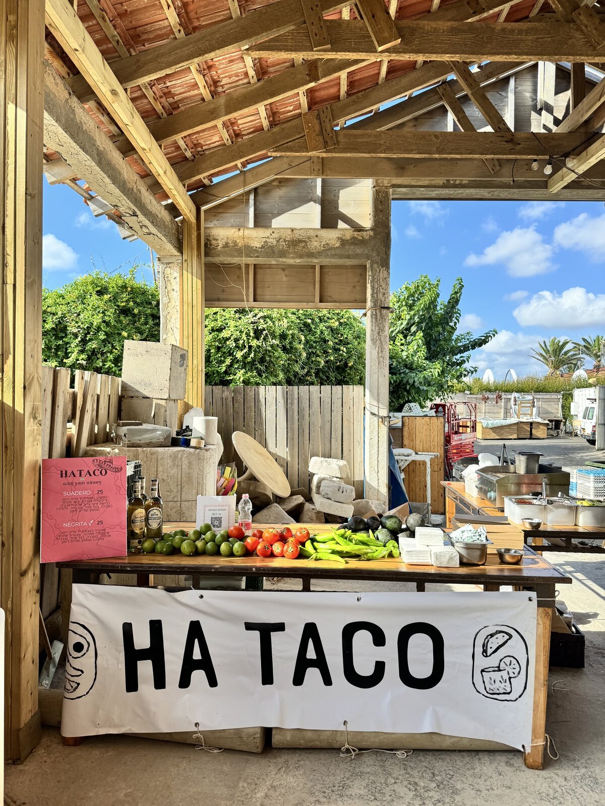Large event under a wooden pergola with a HA TACO banner