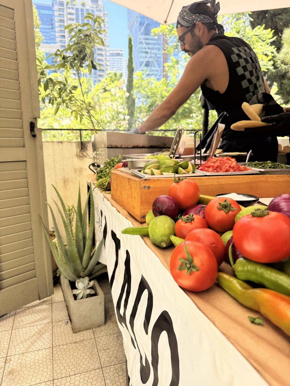 Cook grilling at a villa station with a skyline behind