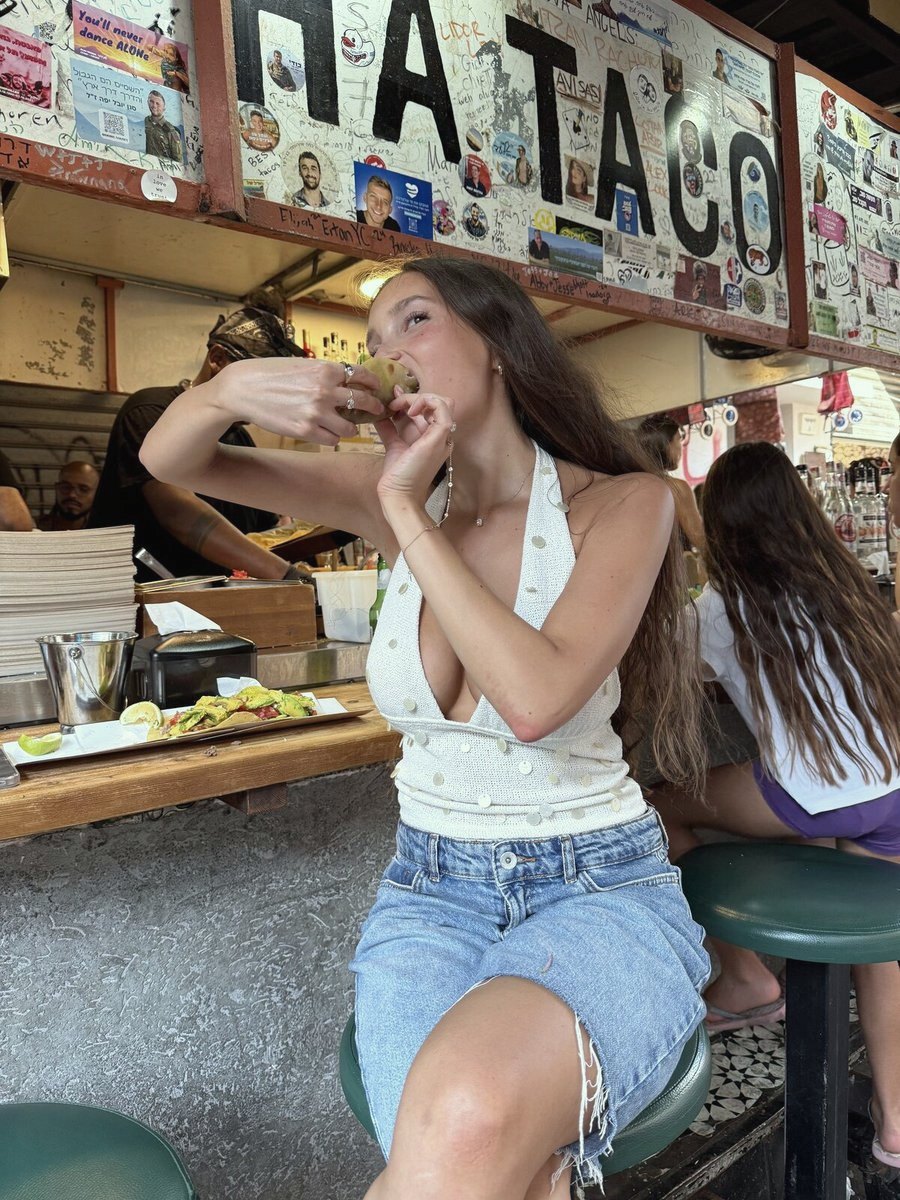 לקוחה נוגסת בטאקו בדלפק הדוכן